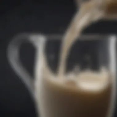 A close-up of whole milk flowing from a jug into a glass